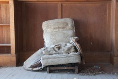 old chair that has fallen apart, stuffing coming out