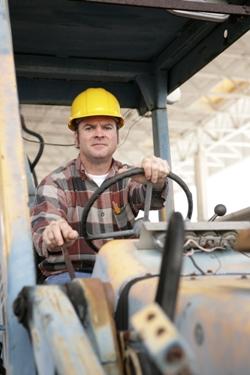 man in yellow hard hat operating heavy equipment