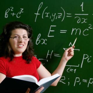 woman at the green board, math equation in chalk behind; she is pointing to E=MC squared