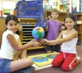 three Montessori students with globe