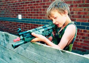 Boy firing toy rifle